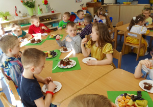 31 Dzieci jedzą ciasto i owoce